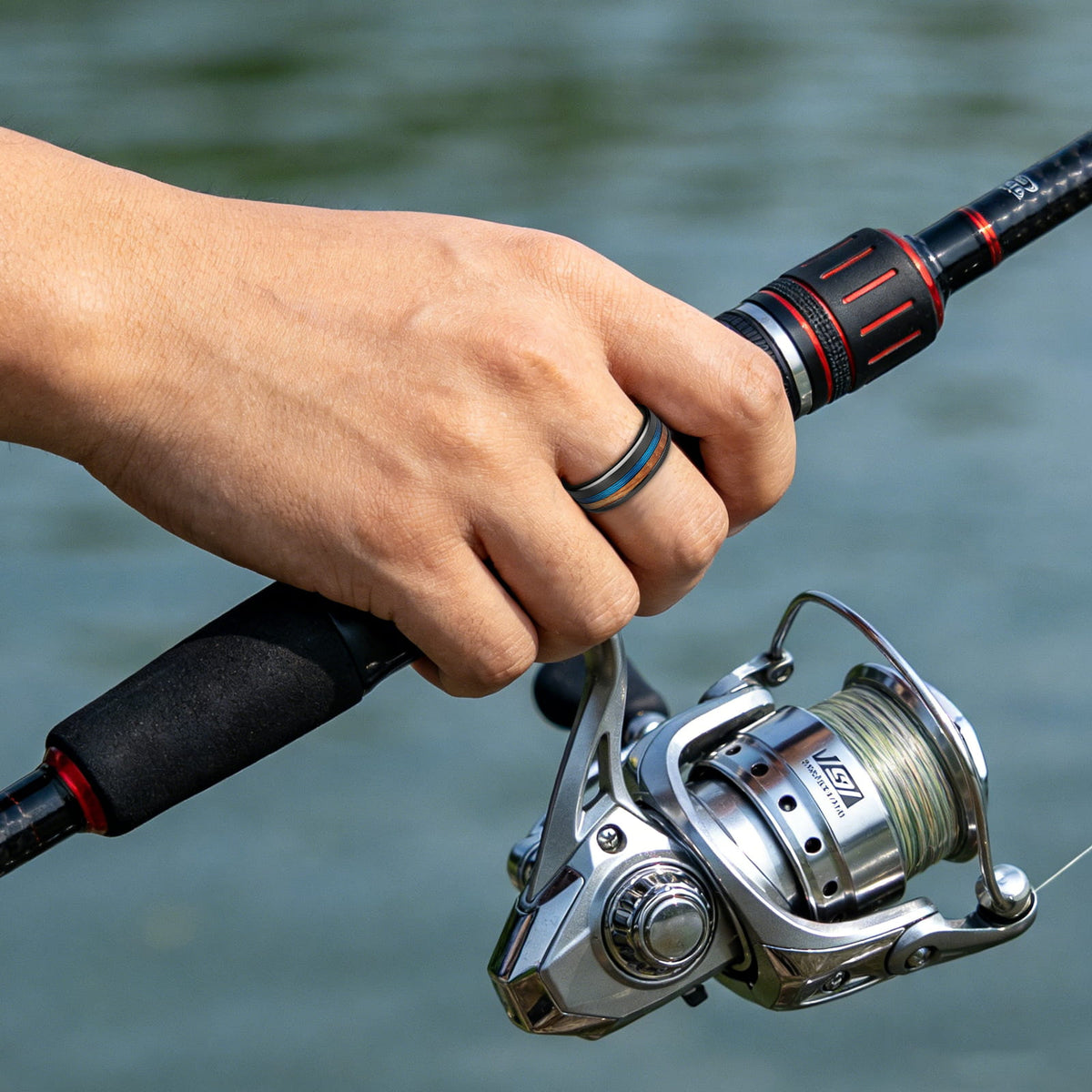 Flat black tungsten ring with offset blue fishing line and whiskey barrel wood beside a wide edge