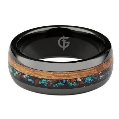 Polished black ceramic ring with brown wood beside blue-green, red and silver-gray inlay fragments.