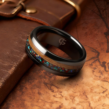 Polished black ceramic ring with brown wood beside blue-green, red and silver-gray inlay fragments.