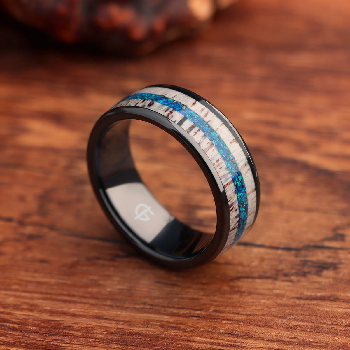 Black ceramic ring with pale deer antler framing blue natural opal and silver-gray meteorite fragments