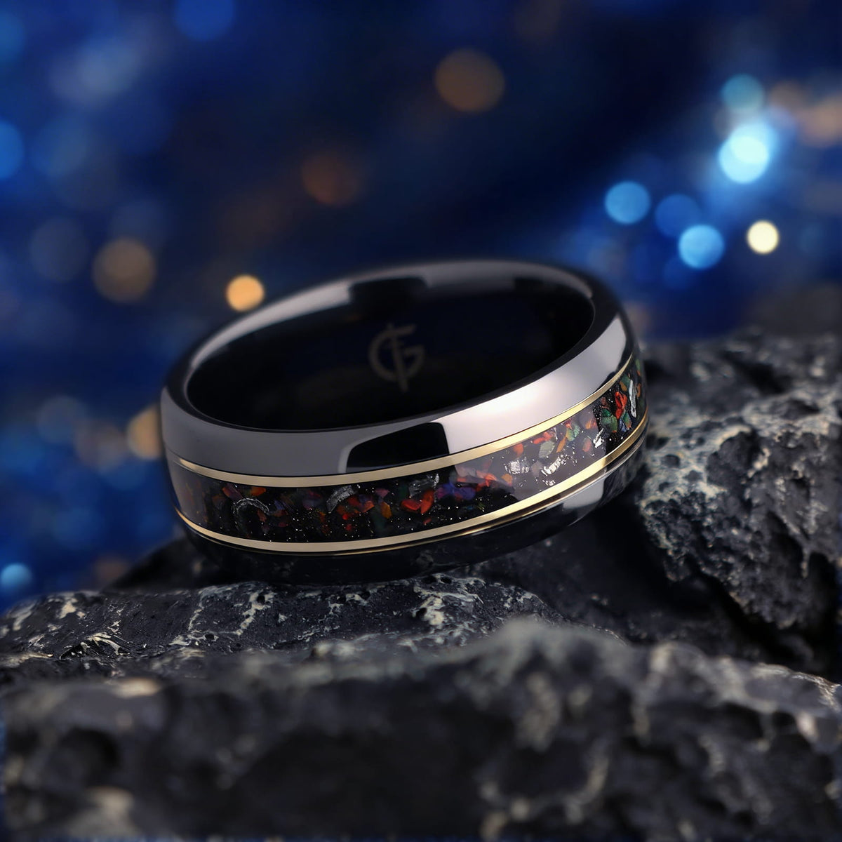 Polished black ceramic ring with multicolored natural opal and silver-gray meteorite fragments framed by two thin brass lines.