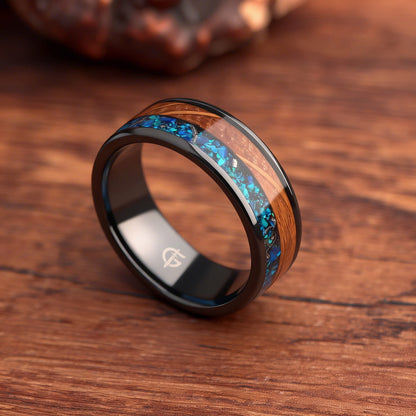 Flat black ceramic ring with brown whiskey barrel wood beside blue natural opal and silver-gray meteorite
