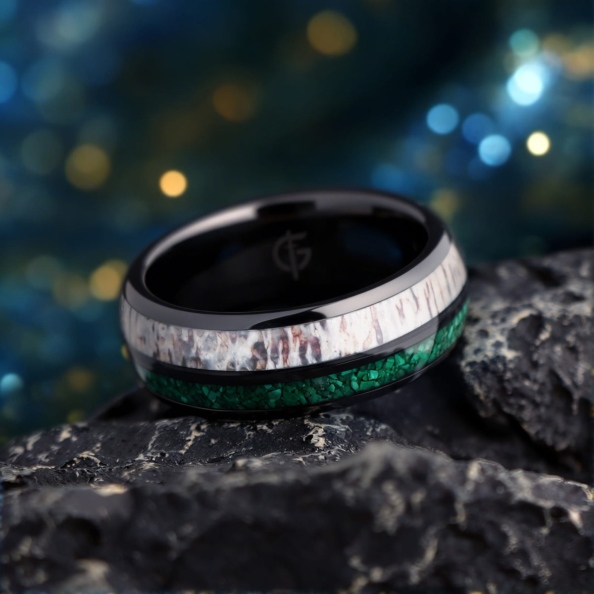 Rounded black ceramic ring with separate green malachite and pale, brown-marked deer antler inlays