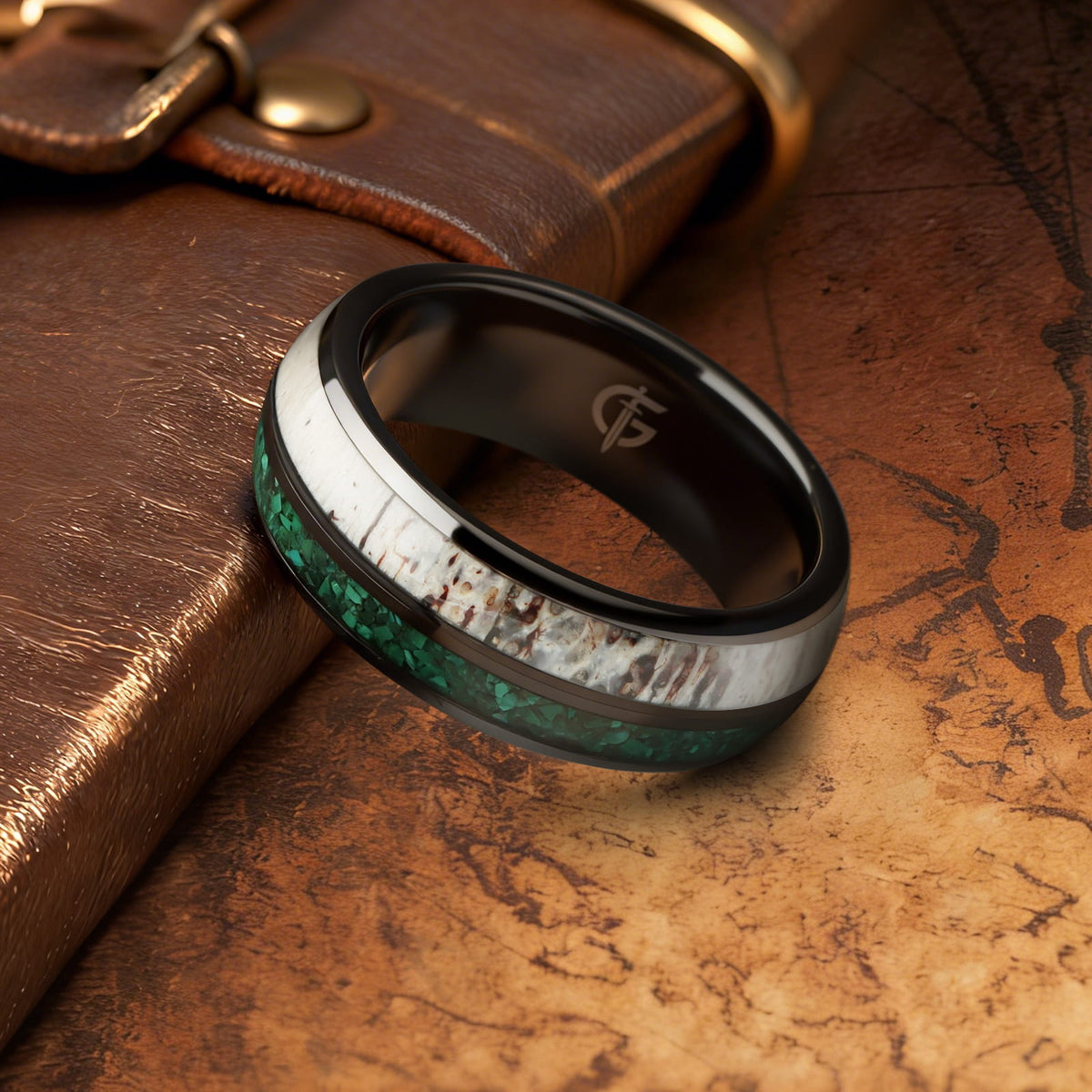 Rounded black ceramic ring with separate green malachite and pale, brown-marked deer antler inlays