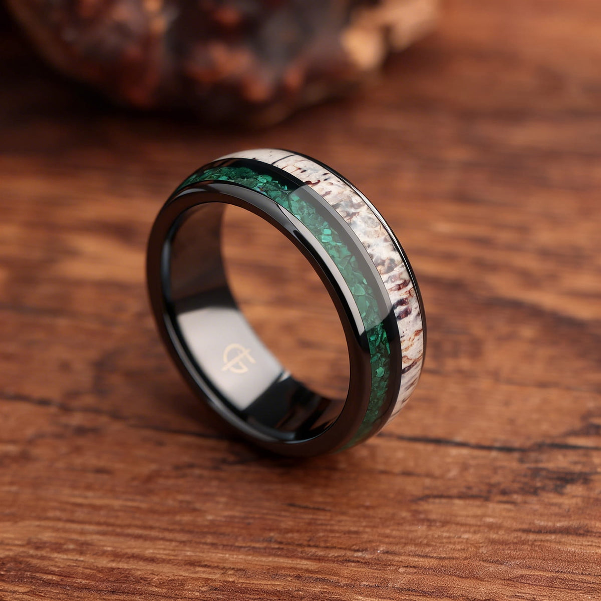 Rounded black ceramic ring with separate green malachite and pale, brown-marked deer antler inlays