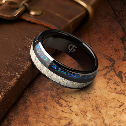 Black ceramic ring with gold-flecked antler beside Sleepy Blue natural opal and meteorite fragments