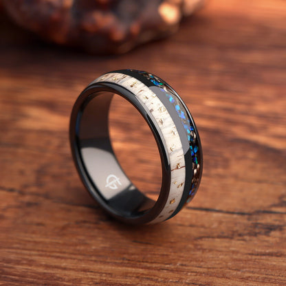 Black ceramic ring with gold-flecked antler beside Sleepy Blue natural opal and meteorite fragments