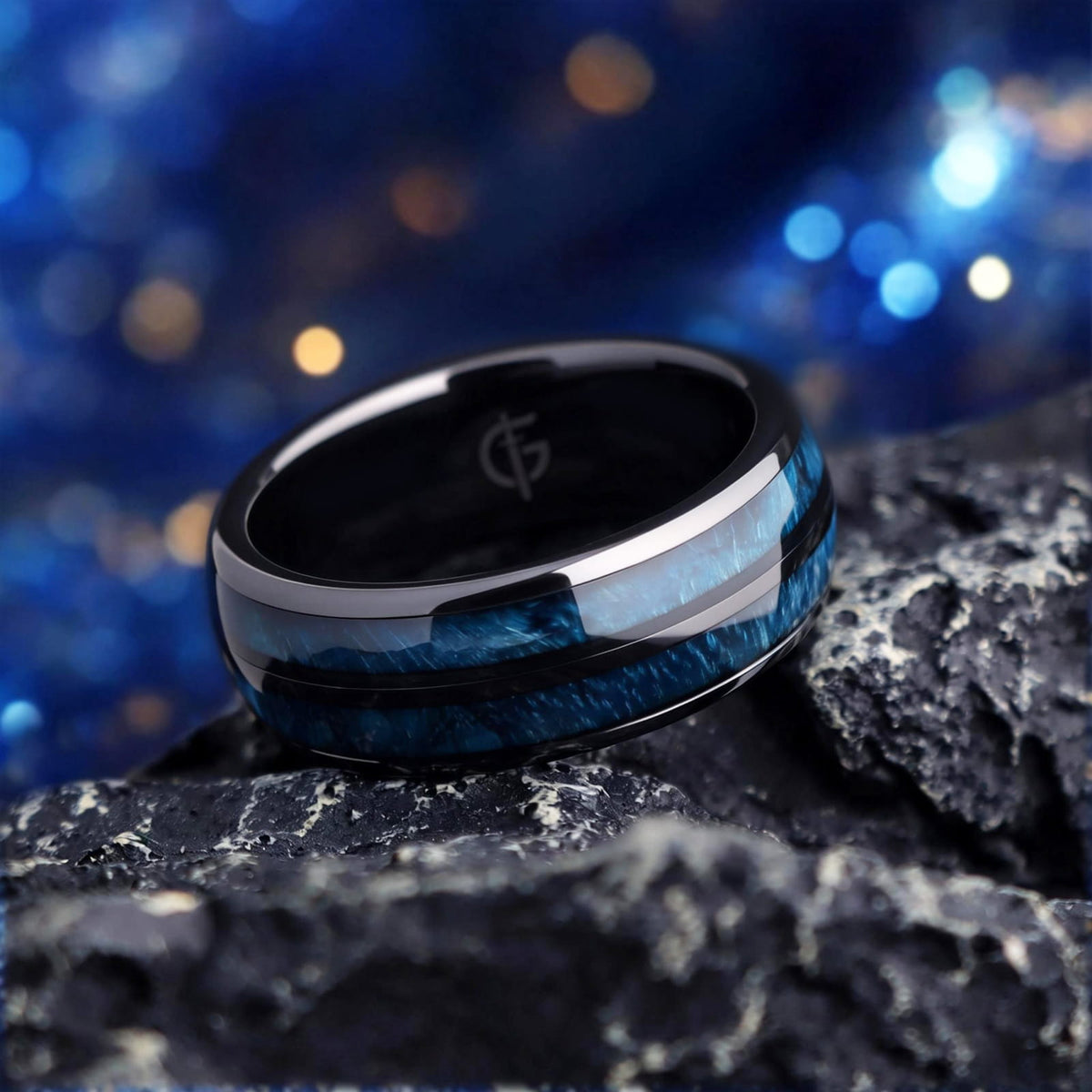 Polished black ceramic ring with two blue whiskey barrel wood inlays separated by a black center strip.