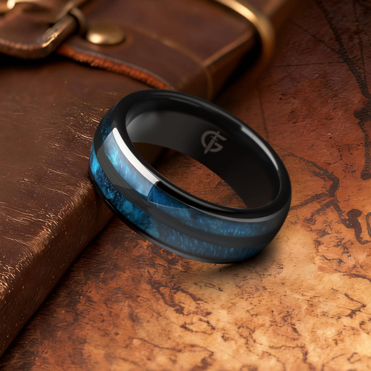 Polished black ceramic ring with two blue whiskey barrel wood inlays separated by a black center strip.