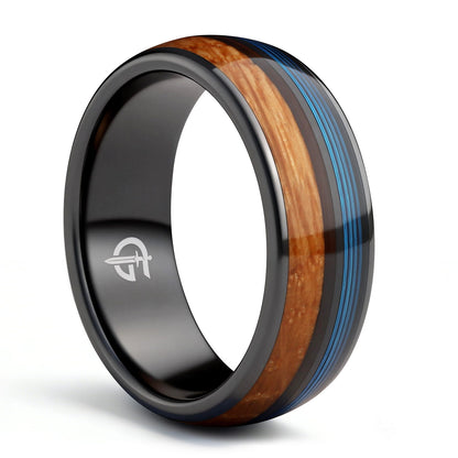 Black ceramic ring with brown whiskey barrel wood and blue fishing line inlays separated by a black strip.