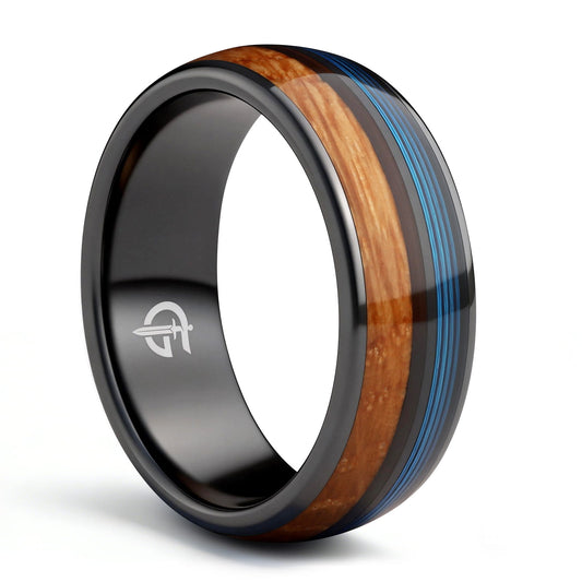 Black ceramic ring with brown whiskey barrel wood and blue fishing line inlays separated by a black strip.