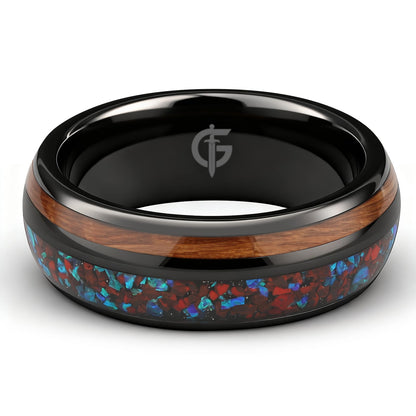 Black ceramic ring with reddish dinosaur bone and blue natural opal beside brown whiskey barrel wood