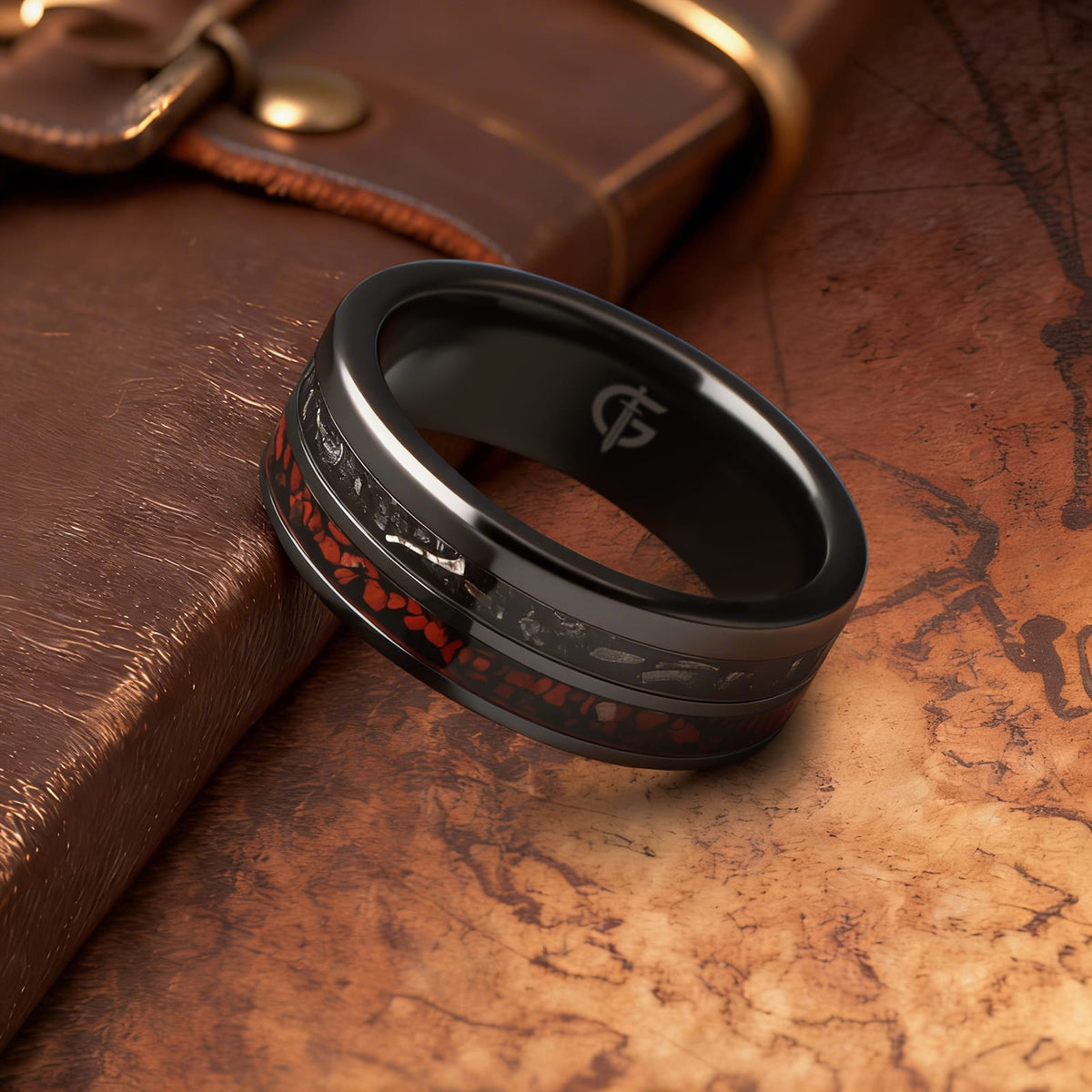 Flat black ceramic ring with red agate and dinosaur bone beside silver-gray meteorite and black agate