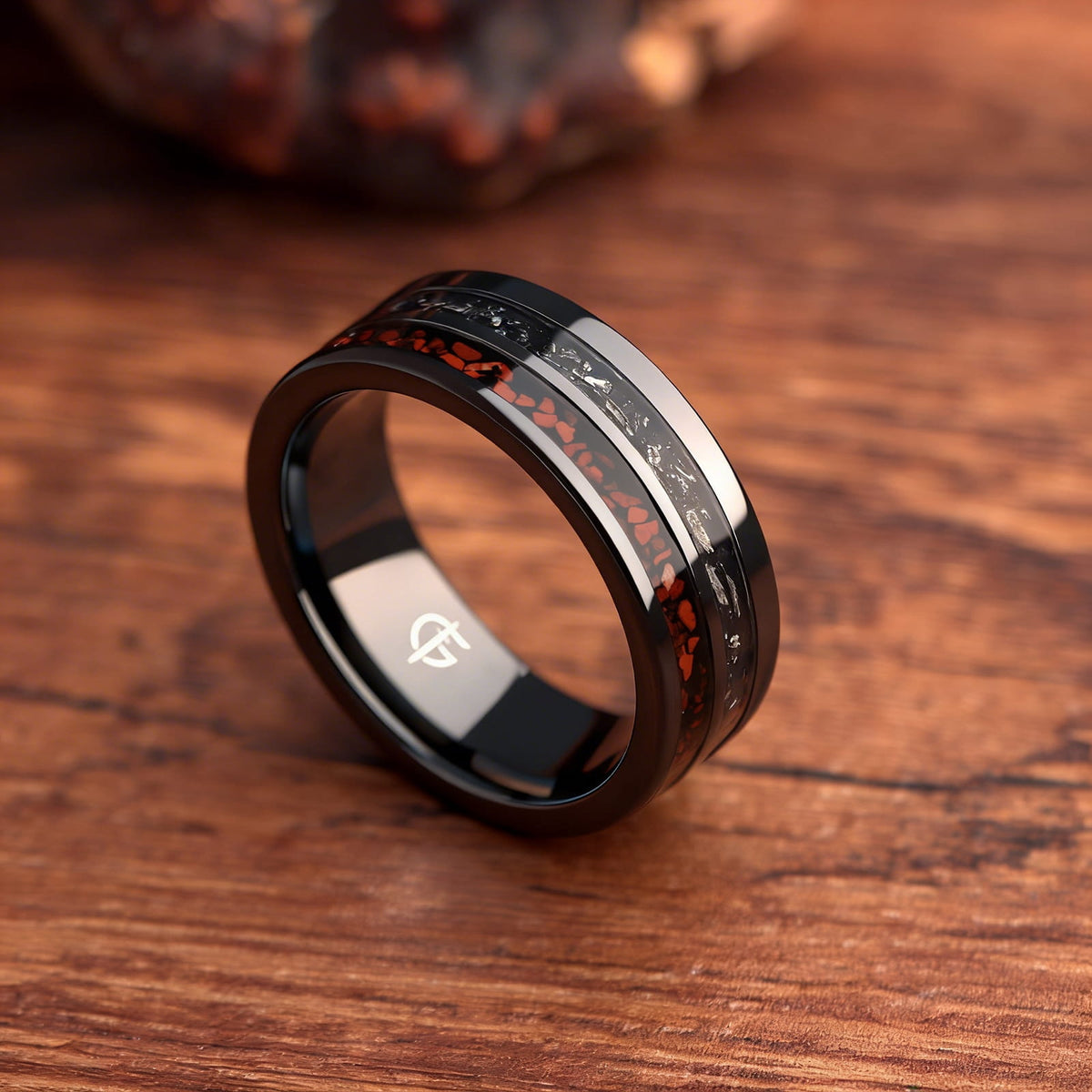 Flat black ceramic ring with red agate and dinosaur bone beside silver-gray meteorite and black agate