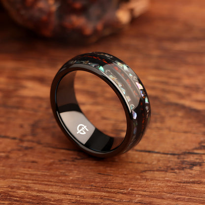 Black ceramic ring with red dinosaur bone center between two iridescent abalone shell and silver-gray meteorite bands.