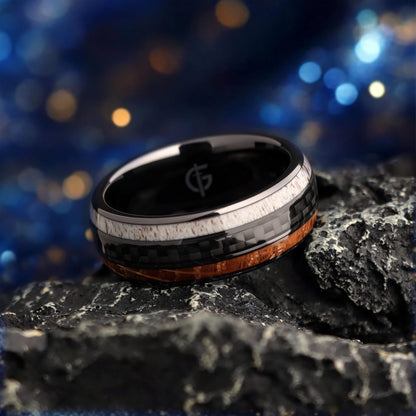 Black ceramic ring with a carbon fiber center between brown wood grain and pale deer antler