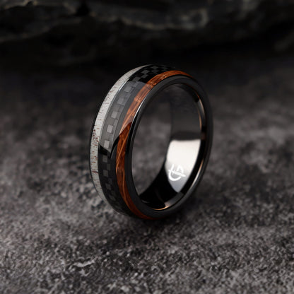 Black ceramic ring with a carbon fiber center between brown wood grain and pale deer antler