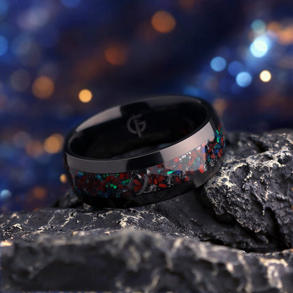 Polished black titanium ring with a mixed inlay of red, blue-green and silver-gray fragments.