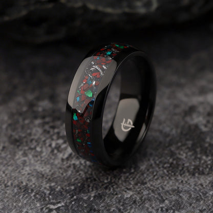 Polished black titanium ring with a mixed inlay of red, blue-green and silver-gray fragments.