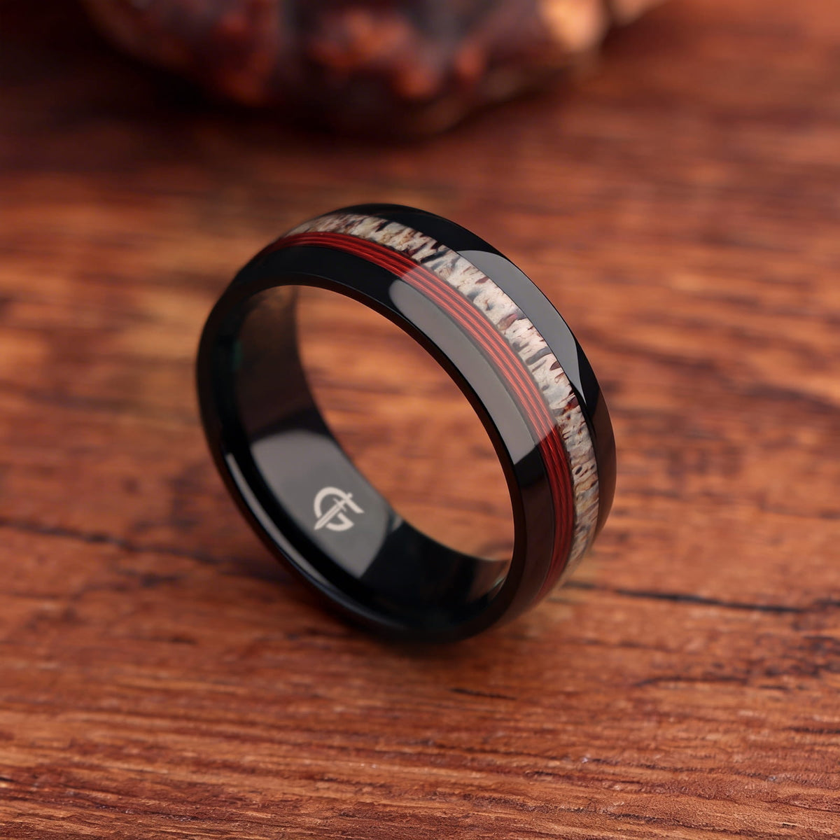 Polished black titanium ring with pale deer antler and parallel red fishing line inlays.