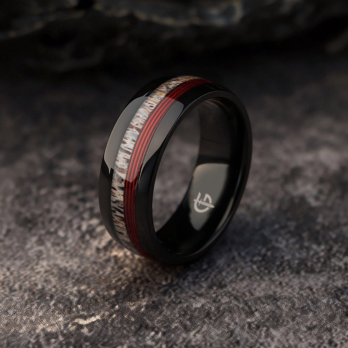 Polished black titanium ring with pale deer antler and parallel red fishing line inlays.