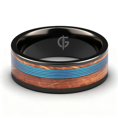 Black titanium ring with blue fishing line centered between brown whiskey barrel wood bands