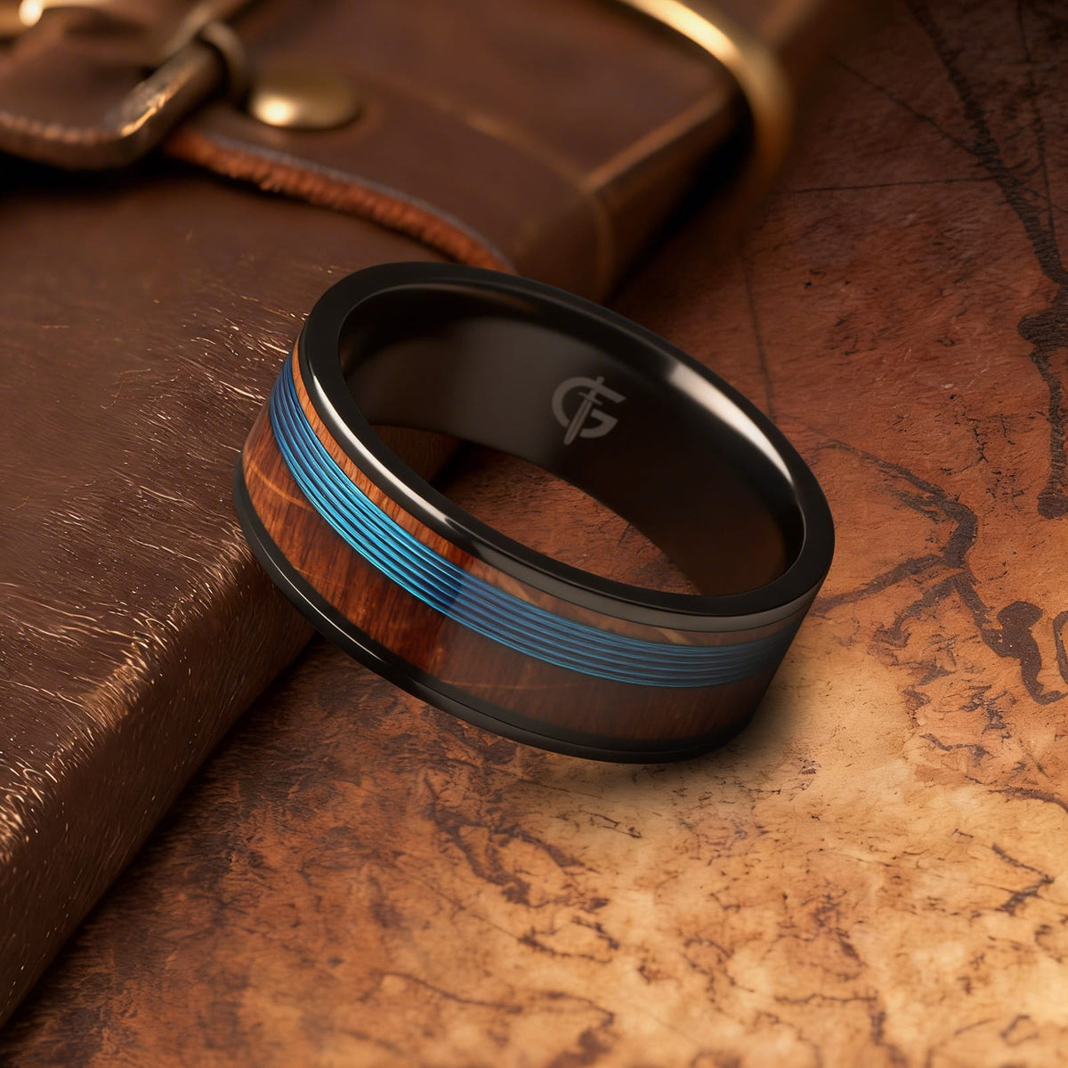 Black titanium ring with blue fishing line centered between brown whiskey barrel wood bands