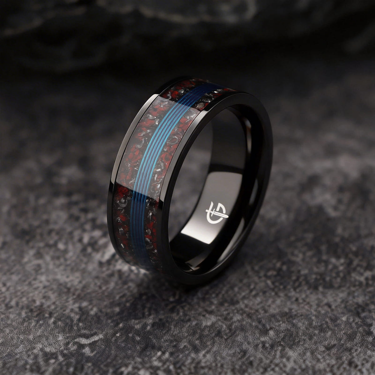 Black titanium ring with blue fishing line centered between mixed red and silver-gray inlay fragments
