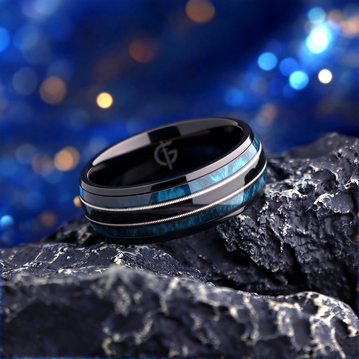 Black titanium ring with blue whiskey barrel wood and silver-tone guitar strings in two mirrored channels