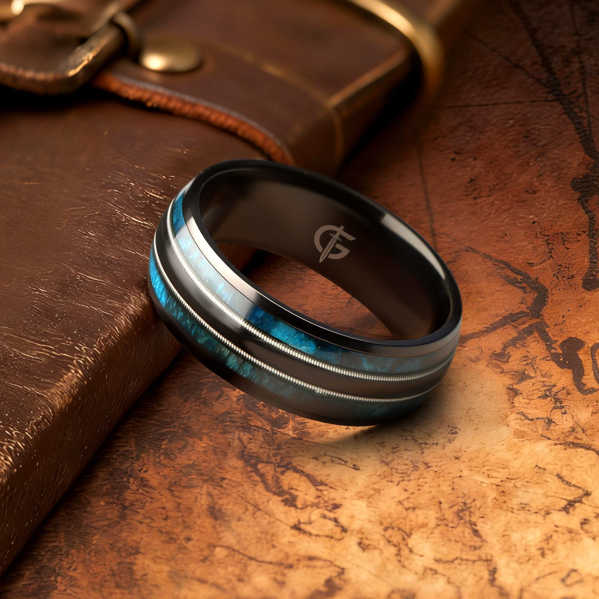 Black titanium ring with blue whiskey barrel wood and silver-tone guitar strings in two mirrored channels