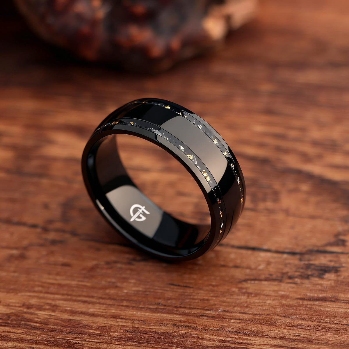 Black titanium ring with a broad polished center and two narrow meteorite and gold leaf inlays