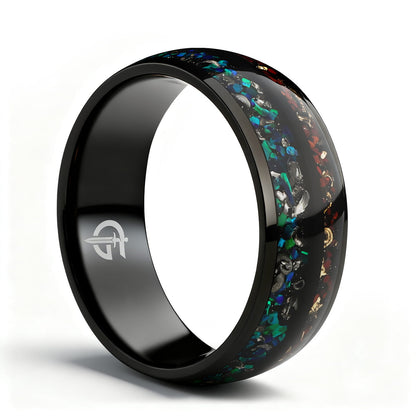 Black titanium ring with two inlays: blue-green opal and meteorite beside reddish-brown bone and copper.