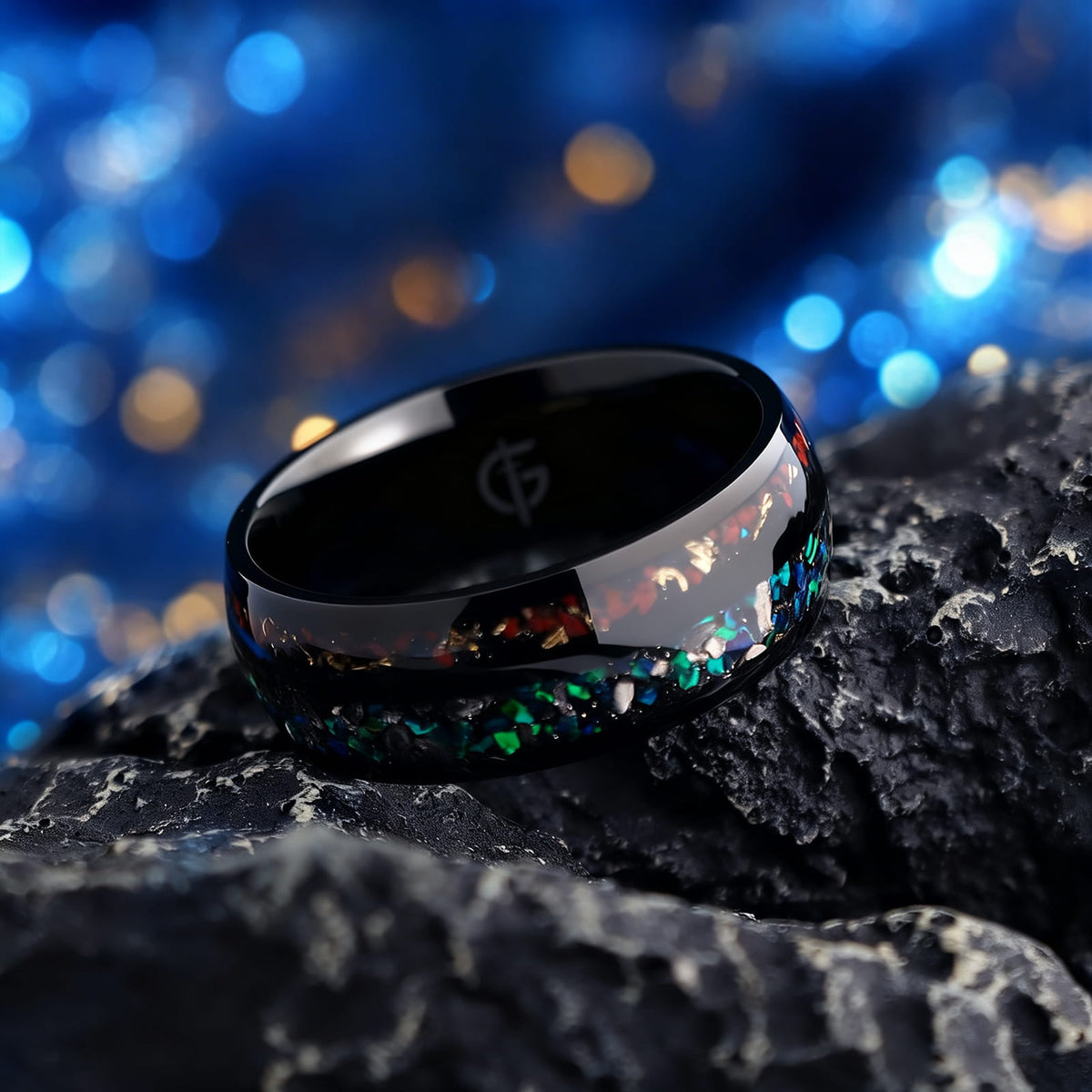Black titanium ring with two inlays: blue-green opal and meteorite beside reddish-brown bone and copper.