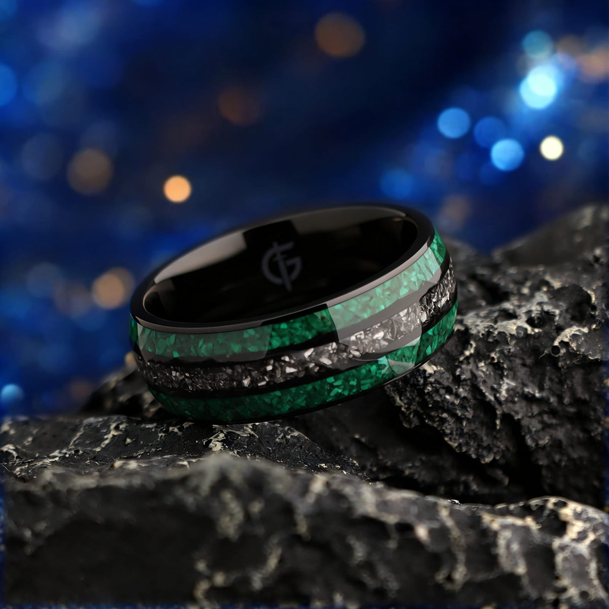 Polished black titanium ring with green malachite channels on either side of silver-gray meteorite.