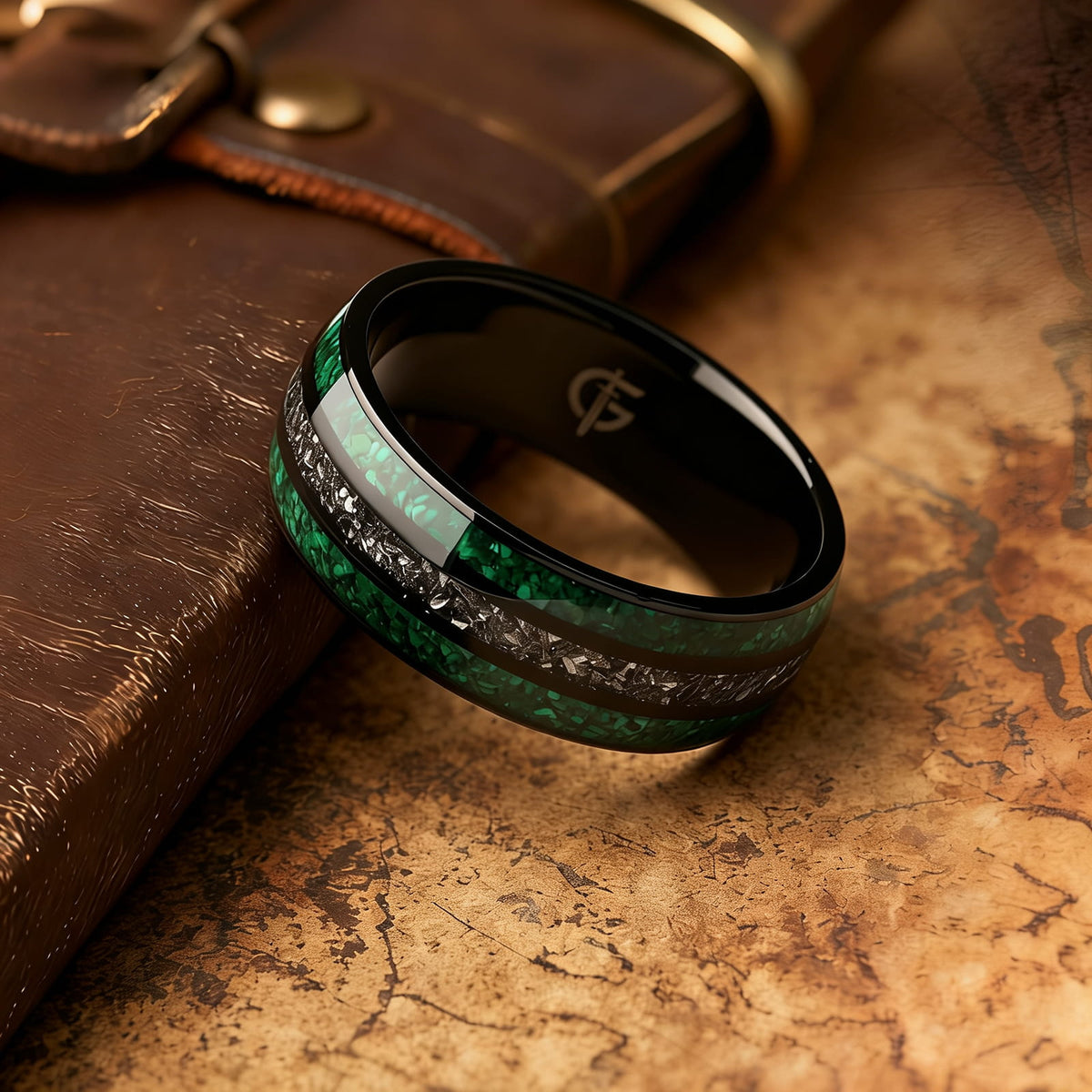 Polished black titanium ring with green malachite channels on either side of silver-gray meteorite.