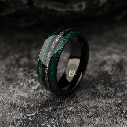 Polished black titanium ring with green malachite channels on either side of silver-gray meteorite.
