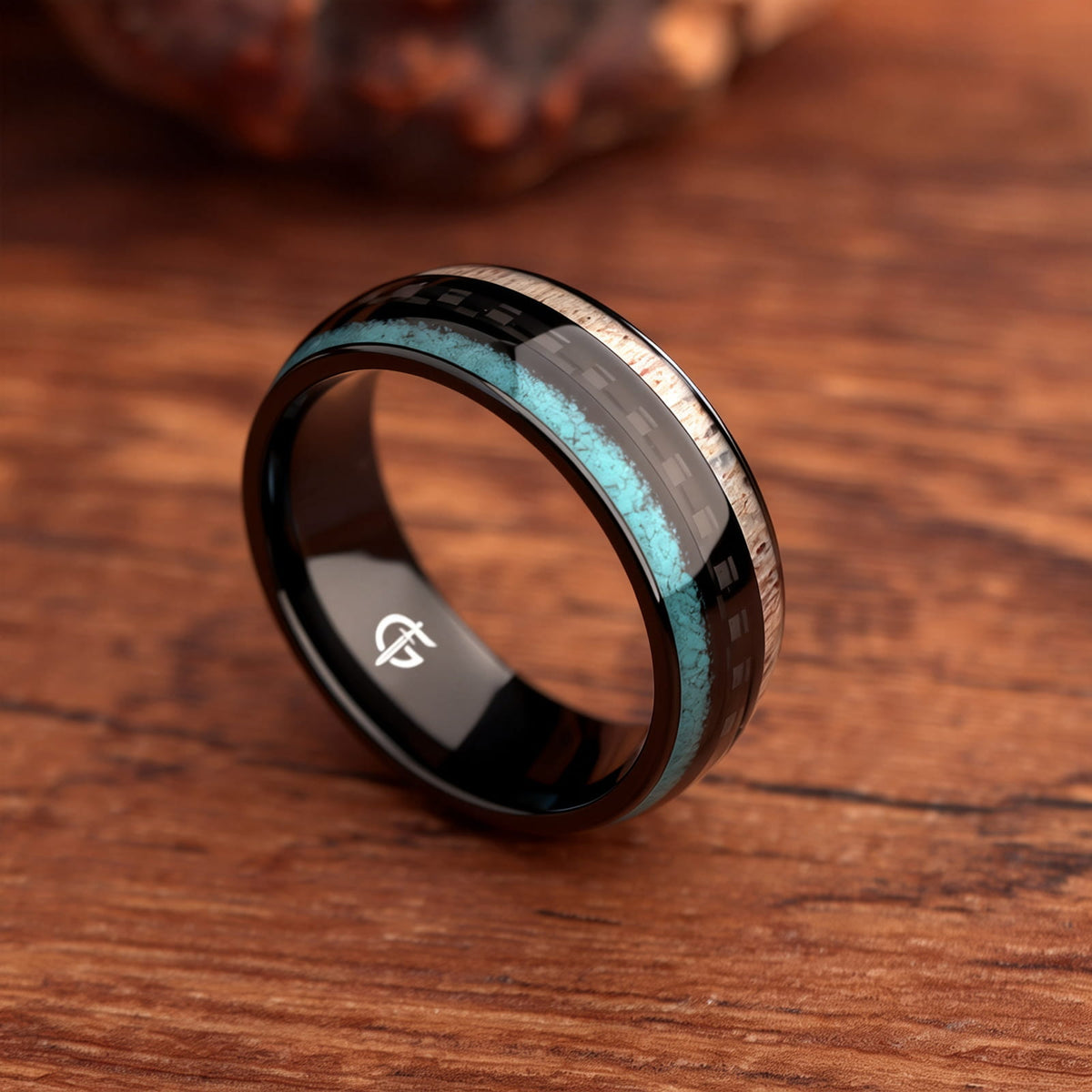 Black titanium ring with pale deer antler and blue turquoise flanking a black carbon fiber center
