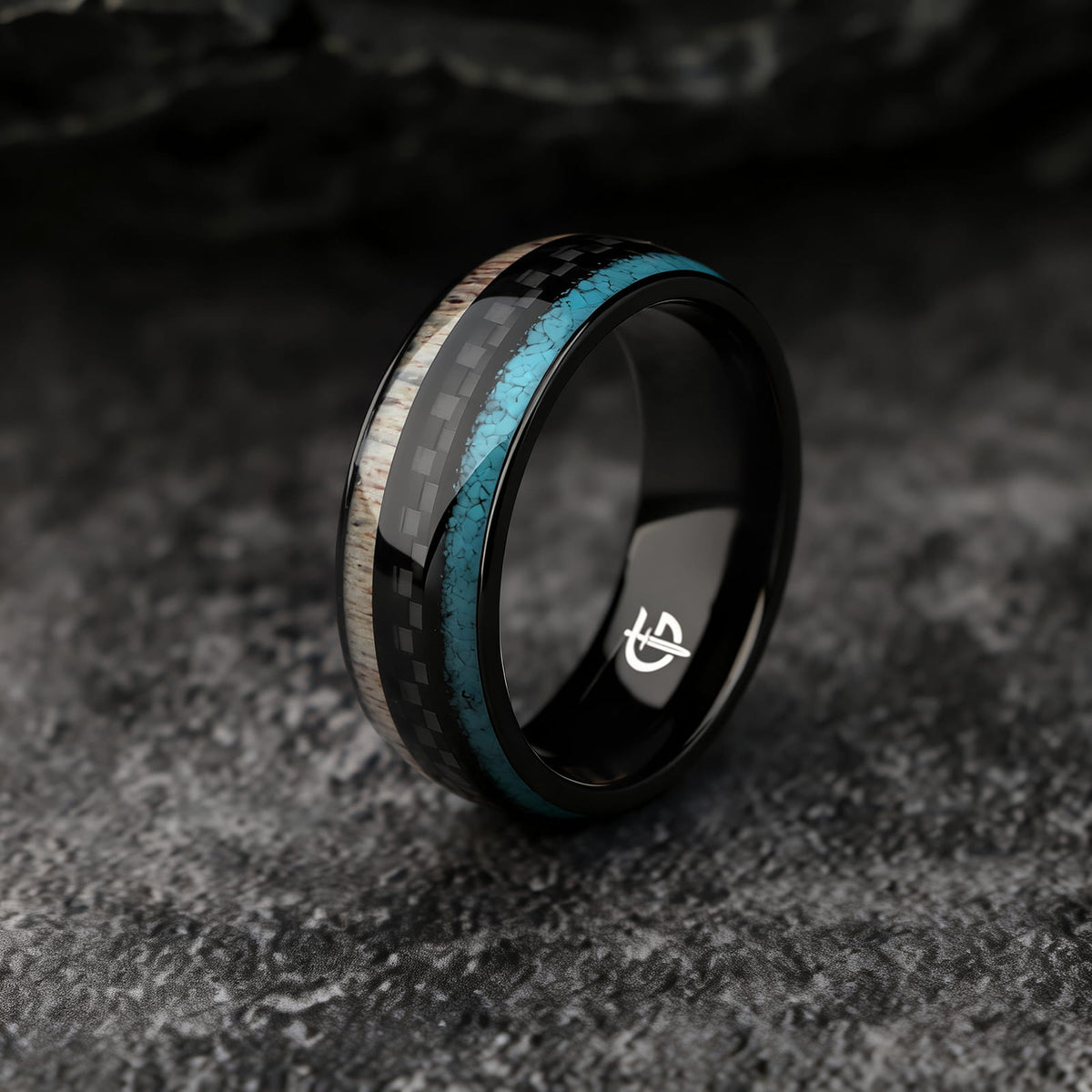 Black titanium ring with pale deer antler and blue turquoise flanking a black carbon fiber center