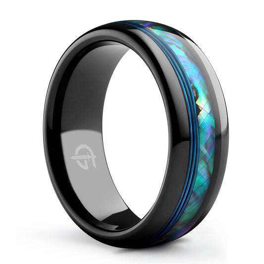 Polished black tungsten carbide ring with blue fishing line beside iridescent blue-green abalone shell inlay.