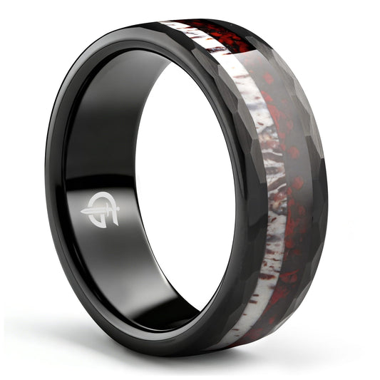 Hammered black tungsten ring with red dinosaur bone beside pale deer antler in a single center inlay