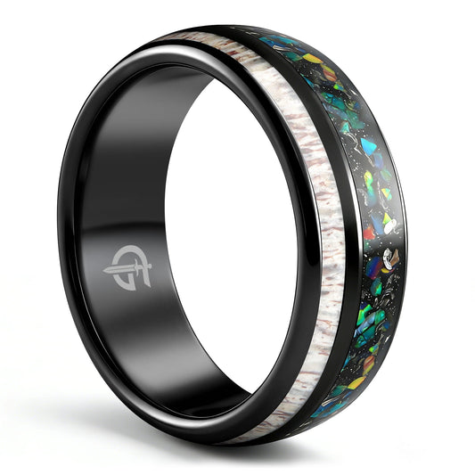 Polished black tungsten ring with pale deer antler beside multicolored opal and silver-colored meteorite fragments