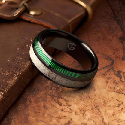 Polished black tungsten ring with pale deer antler beside parallel green fishing line strands