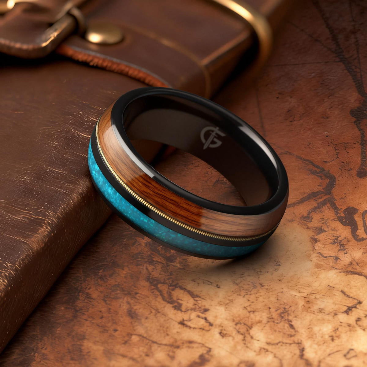 Black tungsten ring with brown whiskey barrel wood, gold-colored guitar string and blue opal inlays