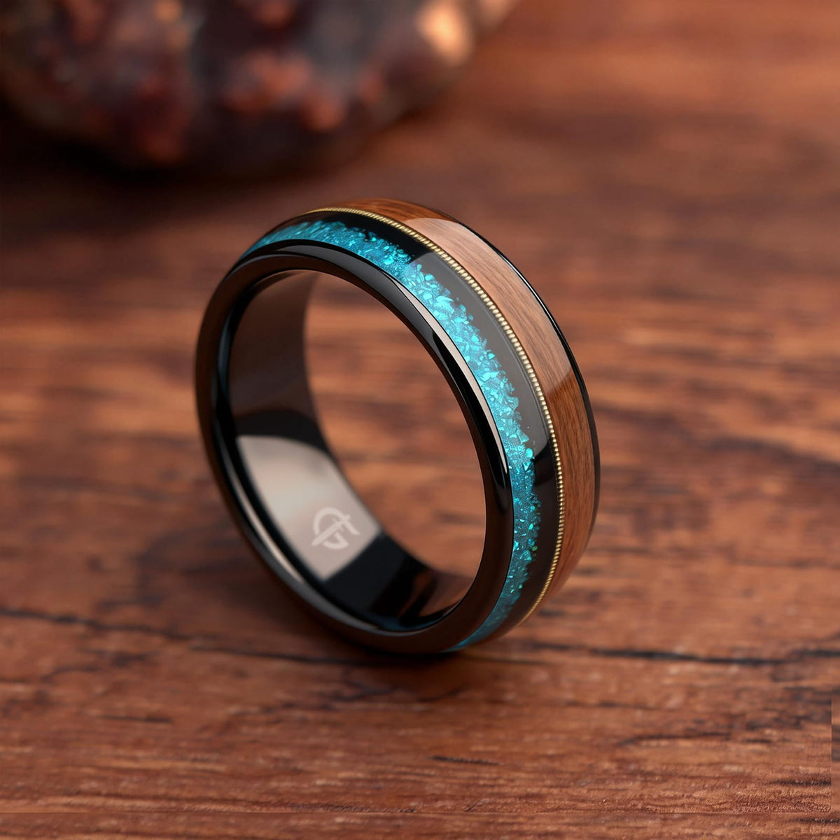 Black tungsten ring with brown whiskey barrel wood, gold-colored guitar string and blue opal inlays