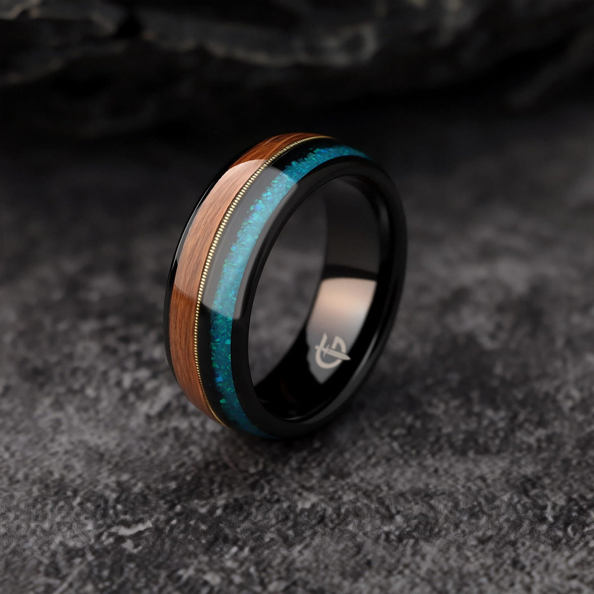 Black tungsten ring with brown whiskey barrel wood, gold-colored guitar string and blue opal inlays
