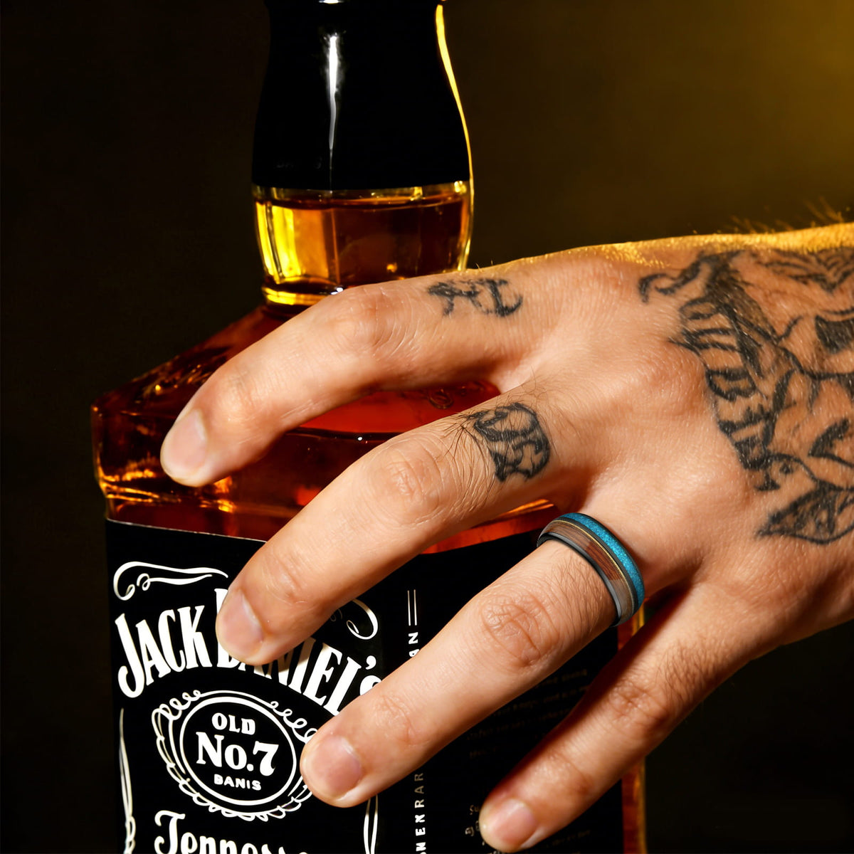 Black tungsten ring with brown whiskey barrel wood, gold-colored guitar string and blue opal inlays