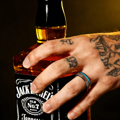 Black tungsten ring with brown whiskey barrel wood, gold-colored guitar string and blue opal inlays