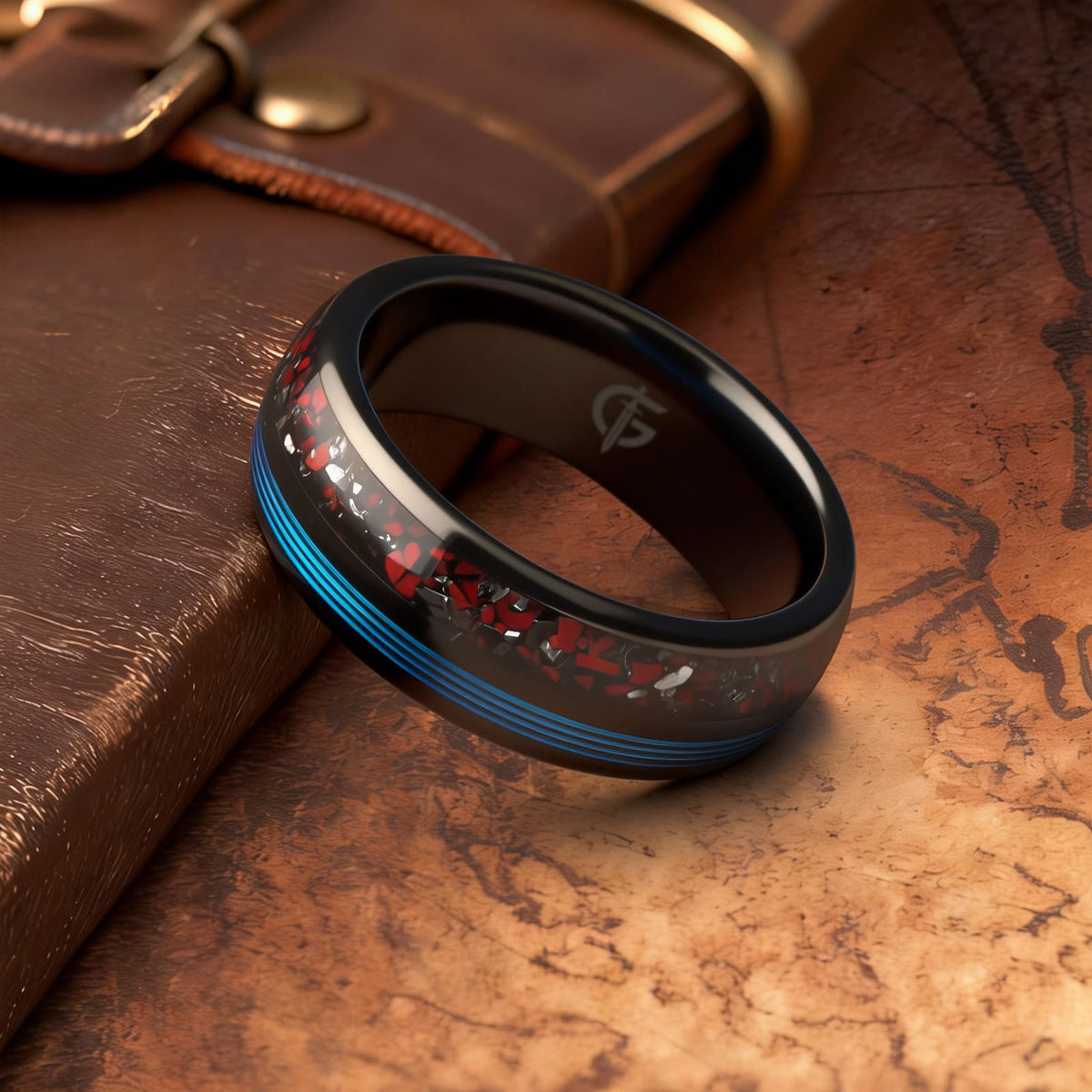 Polished black tungsten ring with fine blue fishing line beside red dinosaur bone and silver-gray meteorite fragments