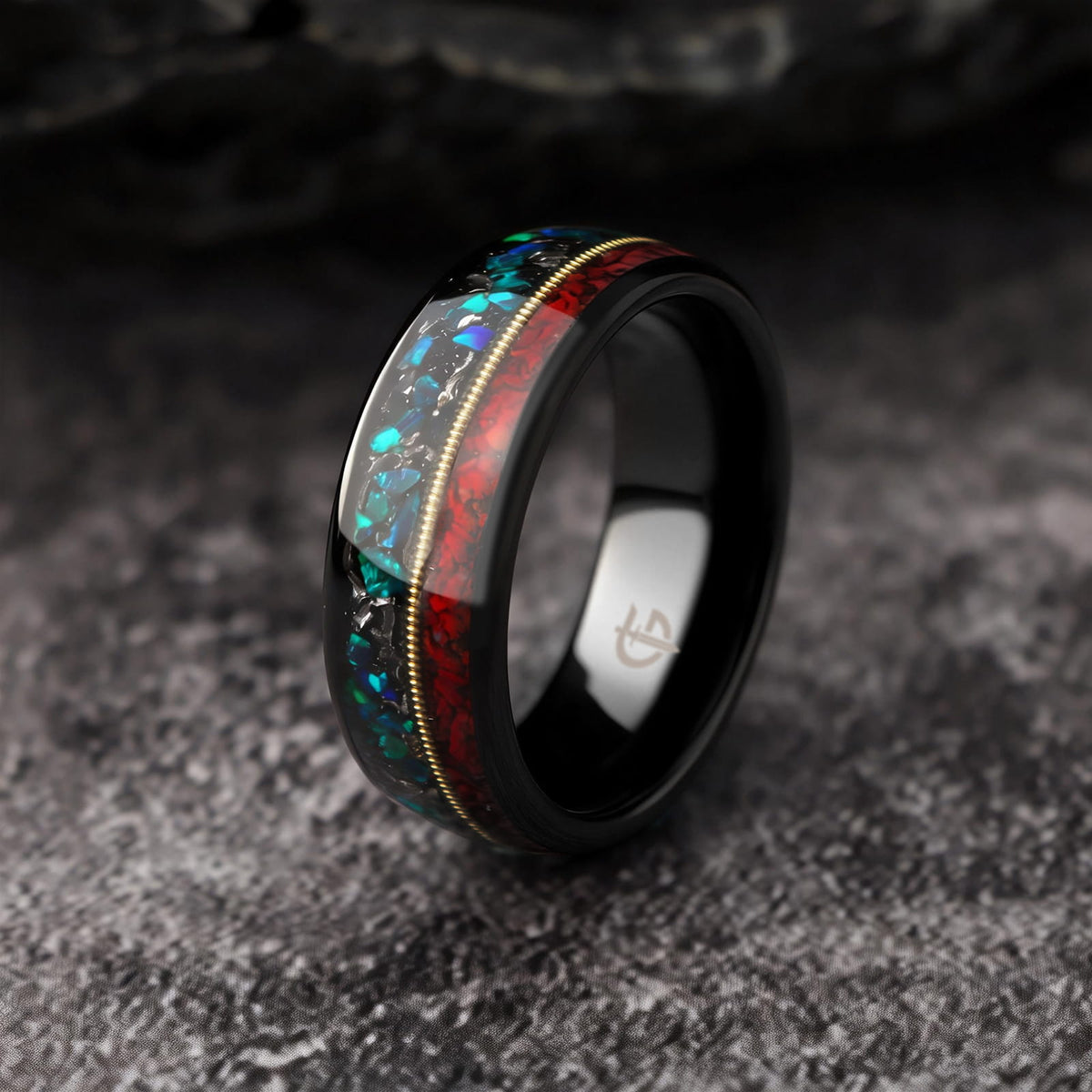 Polished black tungsten ring with gold-colored guitar string between red dinosaur bone and mixed meteorite and blue-green opal