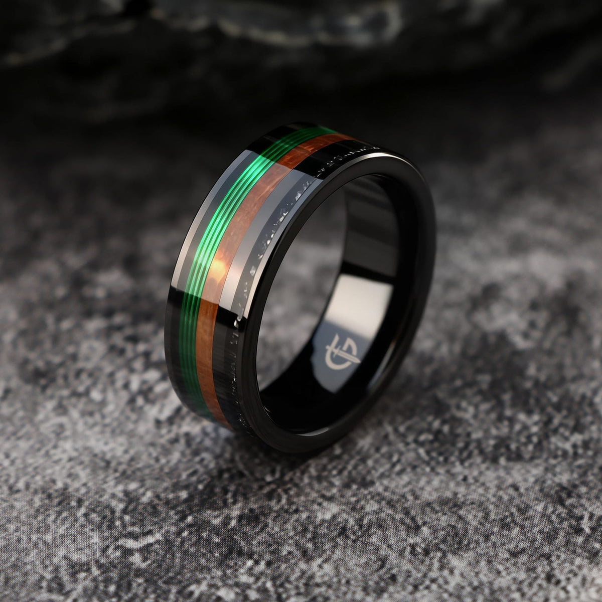 Polished black tungsten carbide ring with green fishing line, brown whiskey barrel wood and silver-gray meteorite